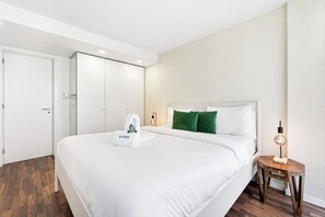 A modern hotel room with a large bed, a wooden nightstand, a wall-mounted lamp, and a patterned wallpaper. - Urban Retreat w/ Balcony | Bright & Central Porto (Porto)