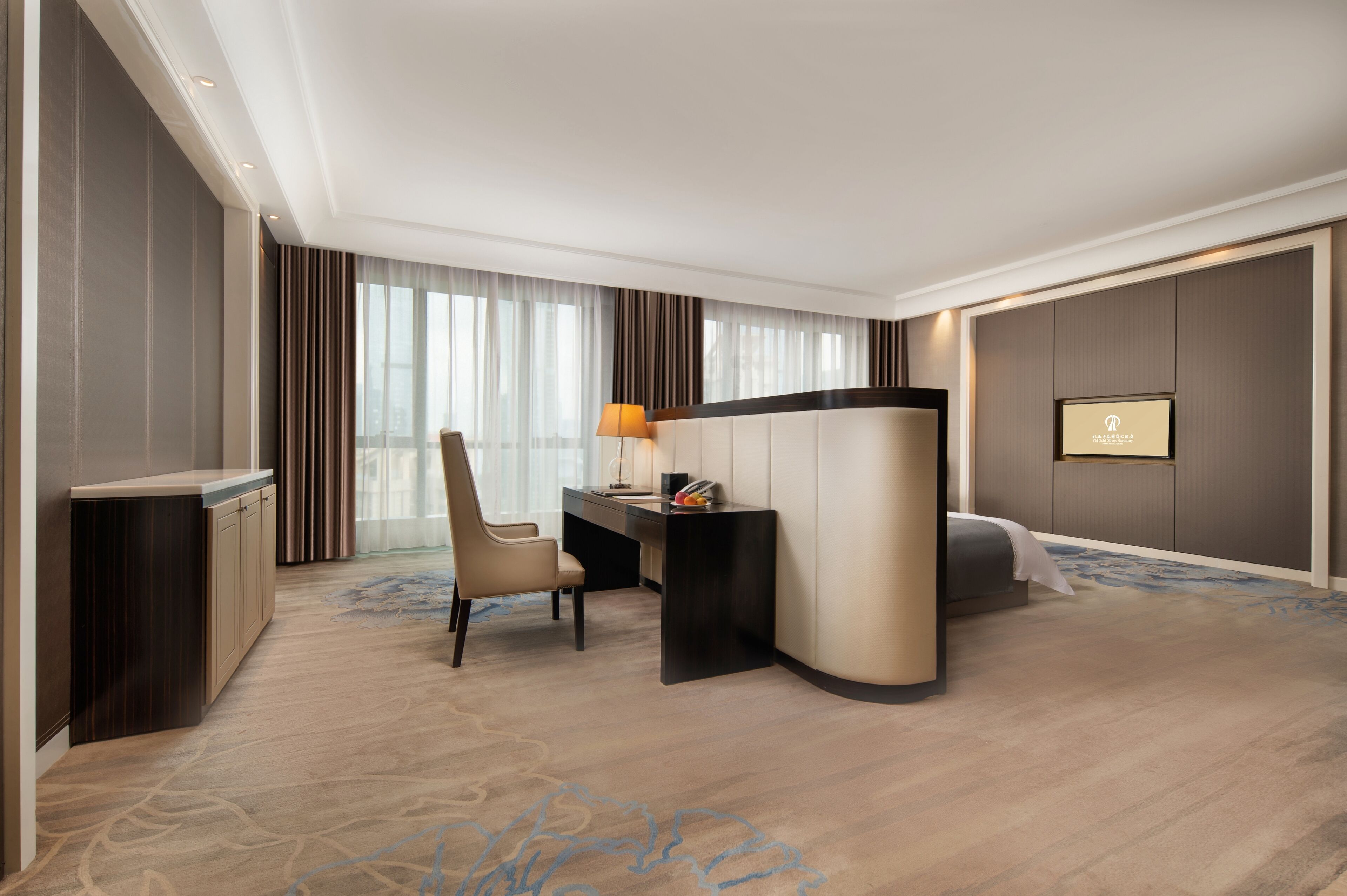 Une chambre d’hôtel équipée d’un bureau, d’une chaise, d’un lit et d’une grande fenêtre avec des rideaux.