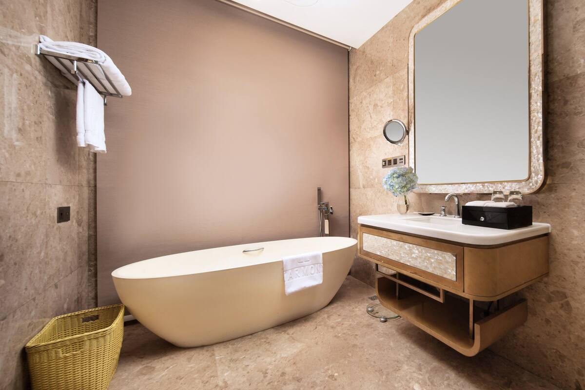 Un baño moderno con una bañera independiente, un tocador con espejo y un perchero para toallas.
