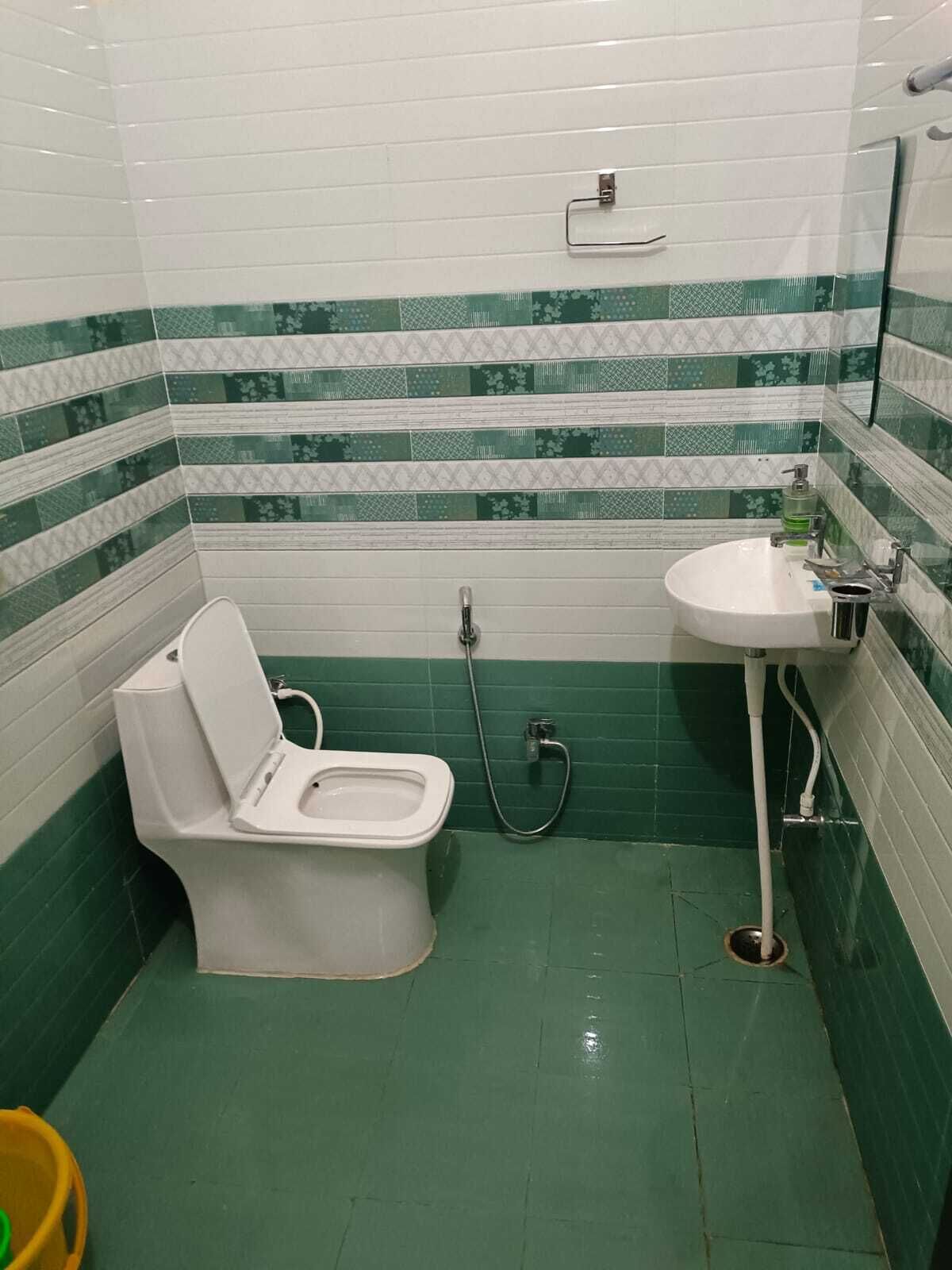 A small bathroom with a toilet, a sink, and a shower.