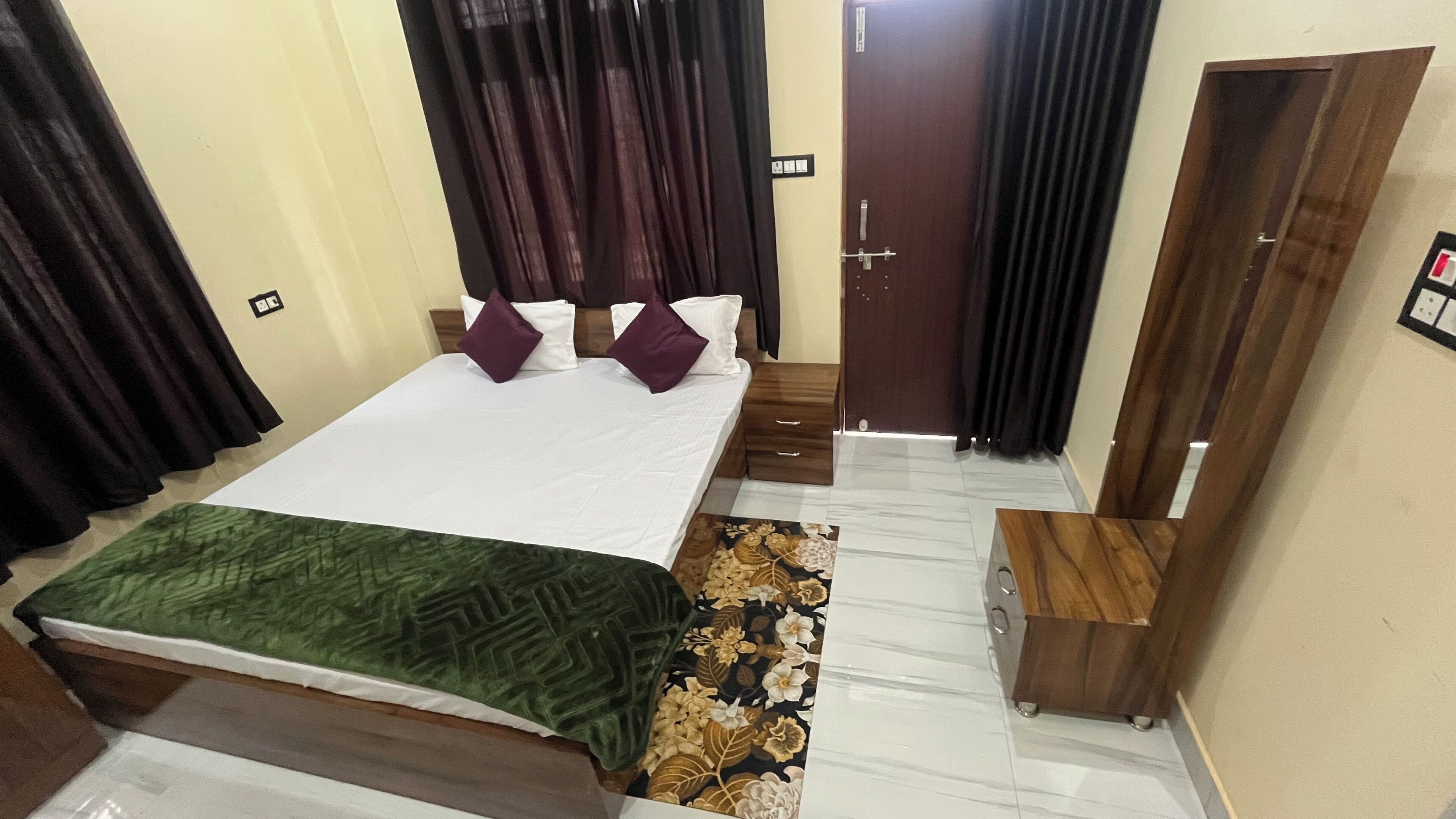 Ein Hotelzimmer mit einem Bett, einem Nachttisch, einer Holzbank und einer Tür.