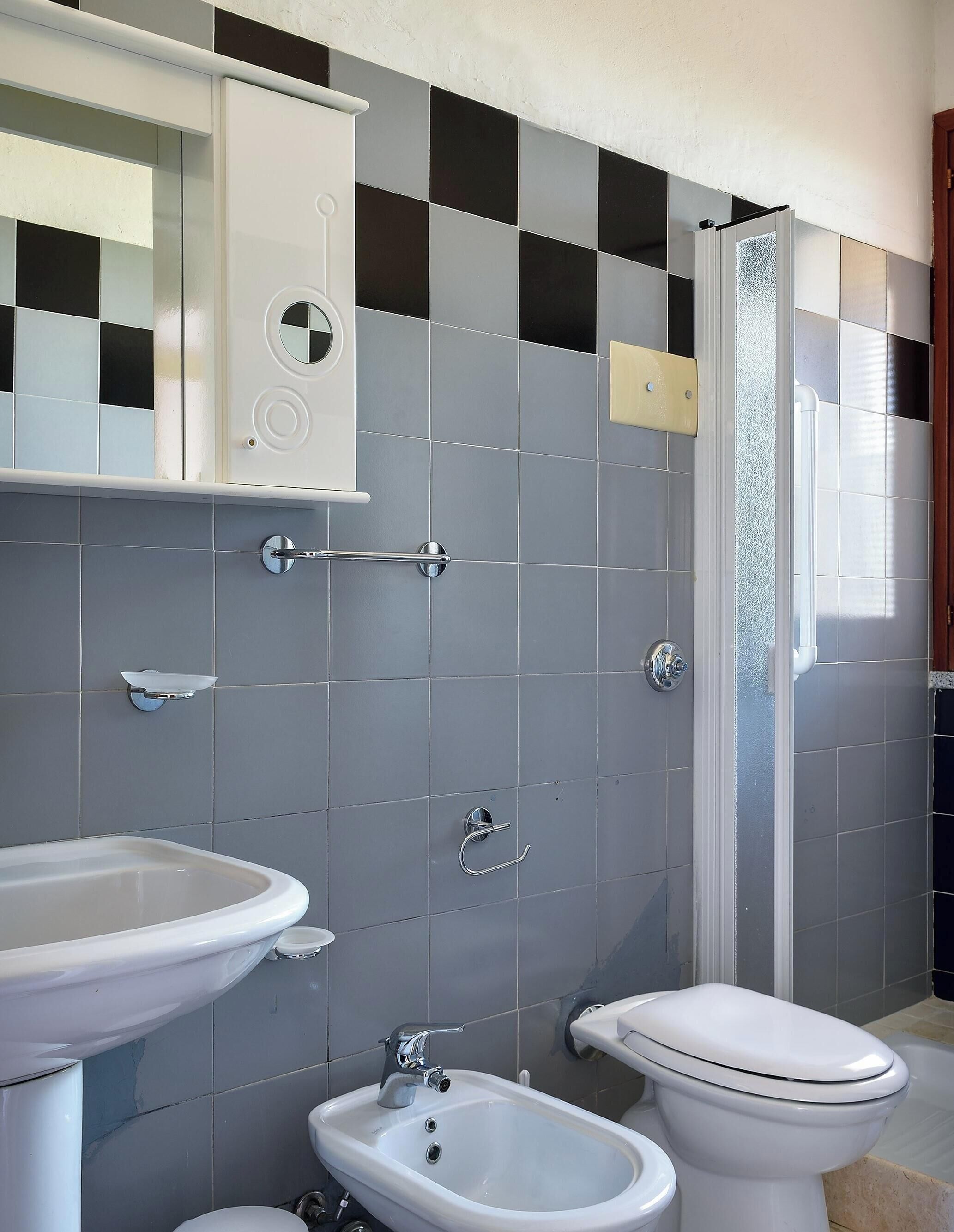 Un bagno con lavandino, bidet, wc e cabina doccia.