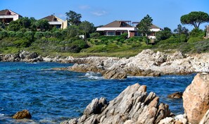 Casas costeras con terreno rocoso y una vista despejada del mar.