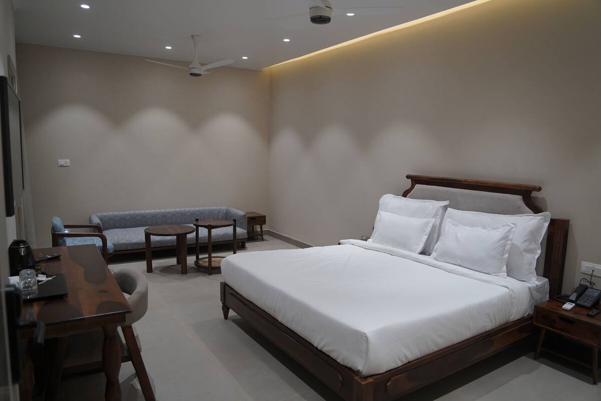 Une chambre d’hôtel moderne, dotée d’un grand lit, d’un canapé, d’un bureau et d’une chaise.