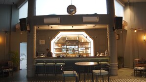 A bar area with a counter, stools, and a patterned floor. - KMR Hotels & Resorts (Bikaner)