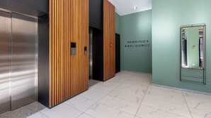 Een modern liftgedeelte met houten lambrisering en een bord dat een parkeerplaats aangeeft.