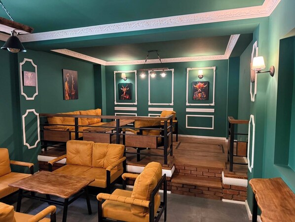 Un restaurante con cabinas y mesas, que presenta obras de arte en las paredes y una pared de ladrillo decorativa.