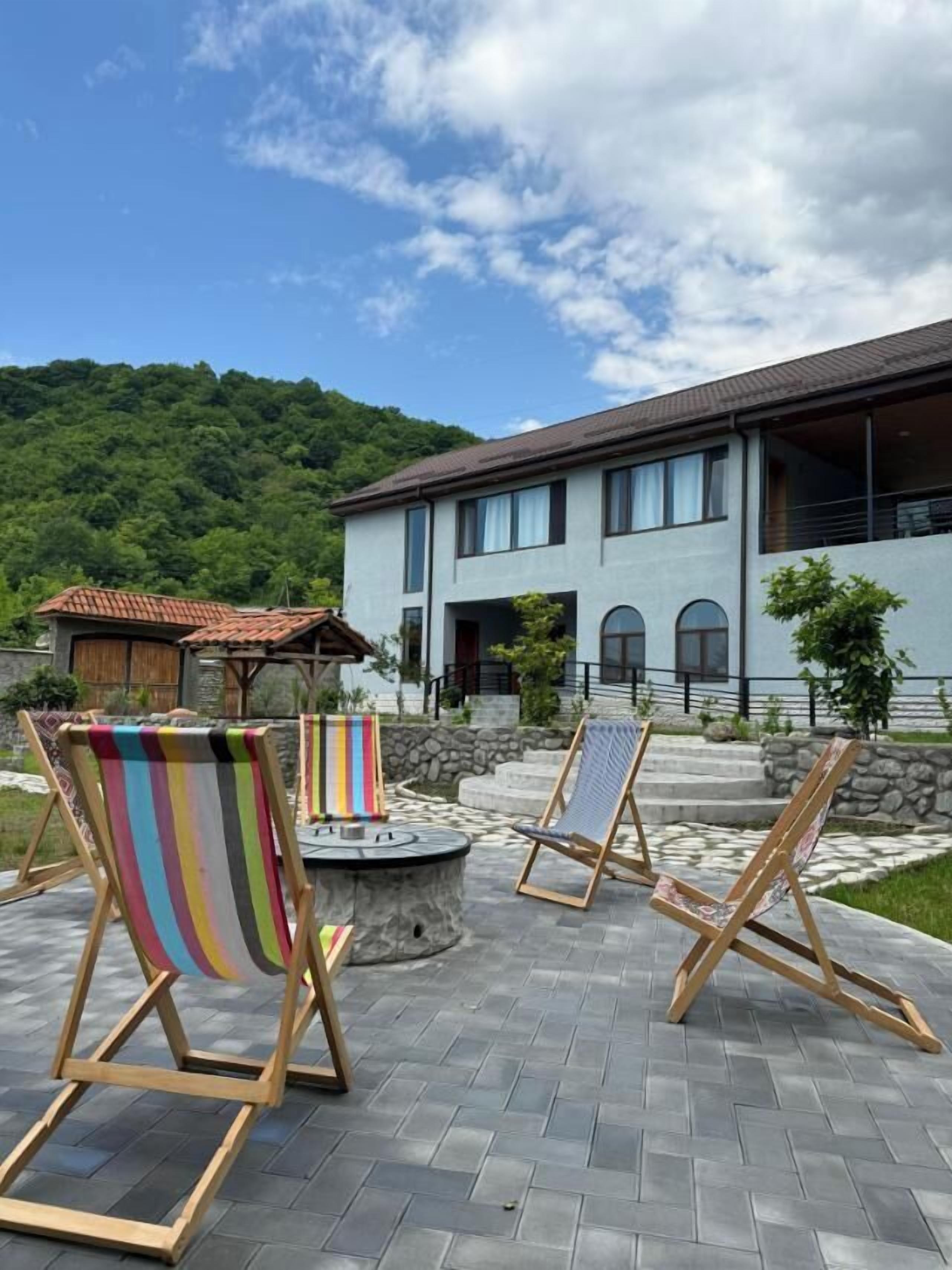 A modern house with a patio area featuring outdoor seating and a fire pit.