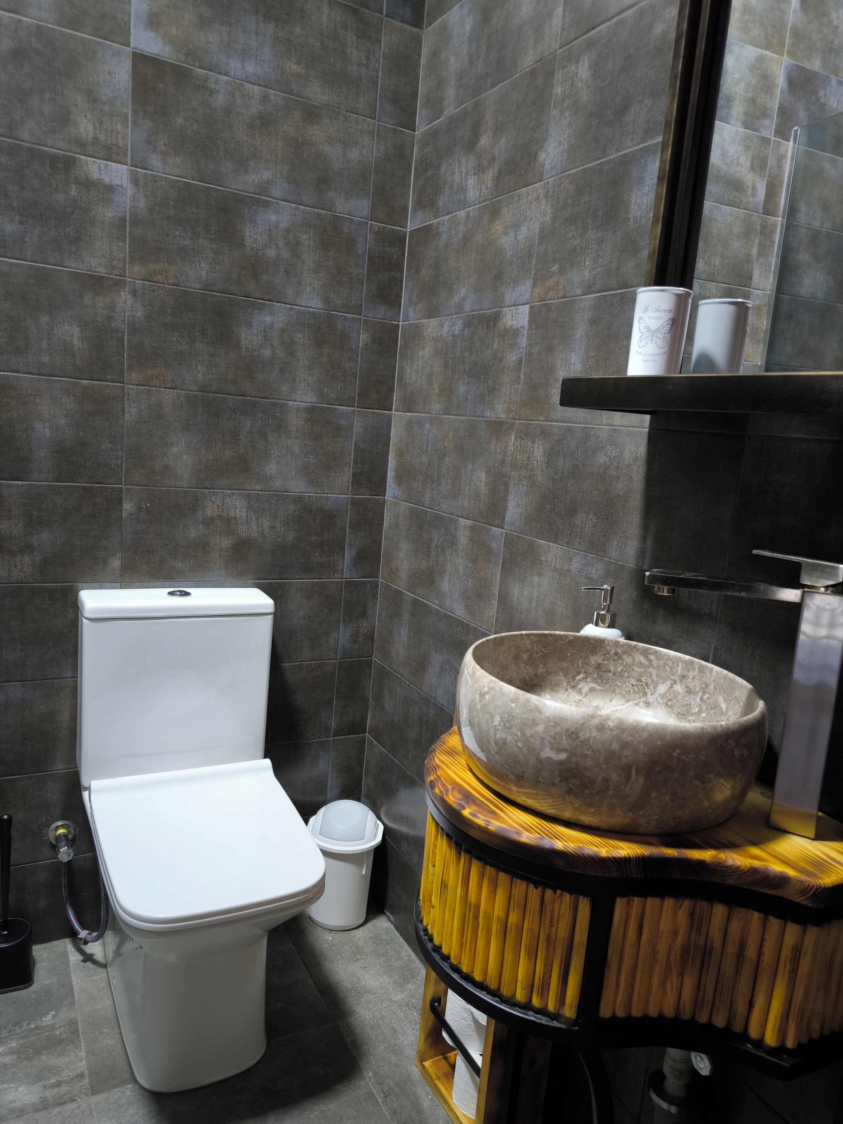 A modern bathroom with a toilet, sink, and mirror.