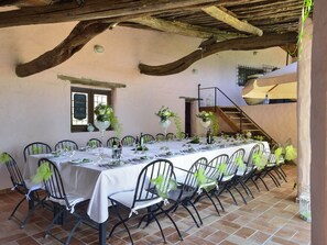 A long dining table set with chairs, a chalkboard menu, and a staircase in the background. - Finca Fiori 1 – Experience Authentic Sardinia in an Exclusive Country Villa (S.Margh.di Pula)