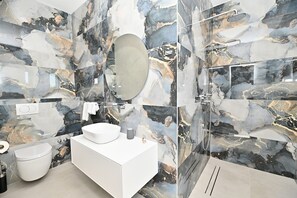 Une salle de bain moderne avec un meuble-lavabo blanc, un grand miroir, un lavabo rond et une cabine de douche en verre.