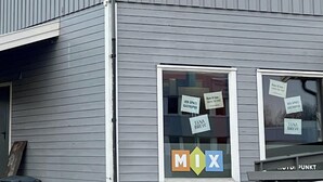 A two-story building with a grey exterior, a covered porch, and a sign advertising 'MIX' and 'TINA BREW'. - Tanabrew  (Tana)