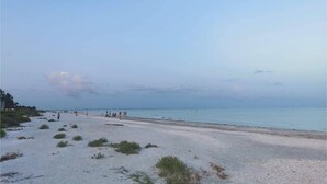 Ein Strand mit sandigem Ufer und blauem Himmel.