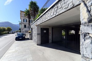 Un edificio de fachada de piedra, un coche aparcado y un cielo despejado.
