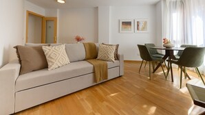 A modern living room with a sofa, dining table, and chairs. - Stylish accommodation: 2 bedrooms, air conditioning and all mod cons HOR1K1B (Madrid)