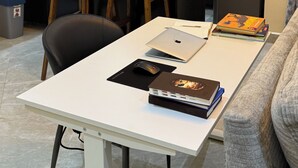 Un espacio habitable compacto con comedor, kitchenette y zona de estar con sofá.