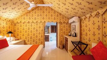 A room with a bed, a nightstand, a lamp, a chair, and a ceiling fan.