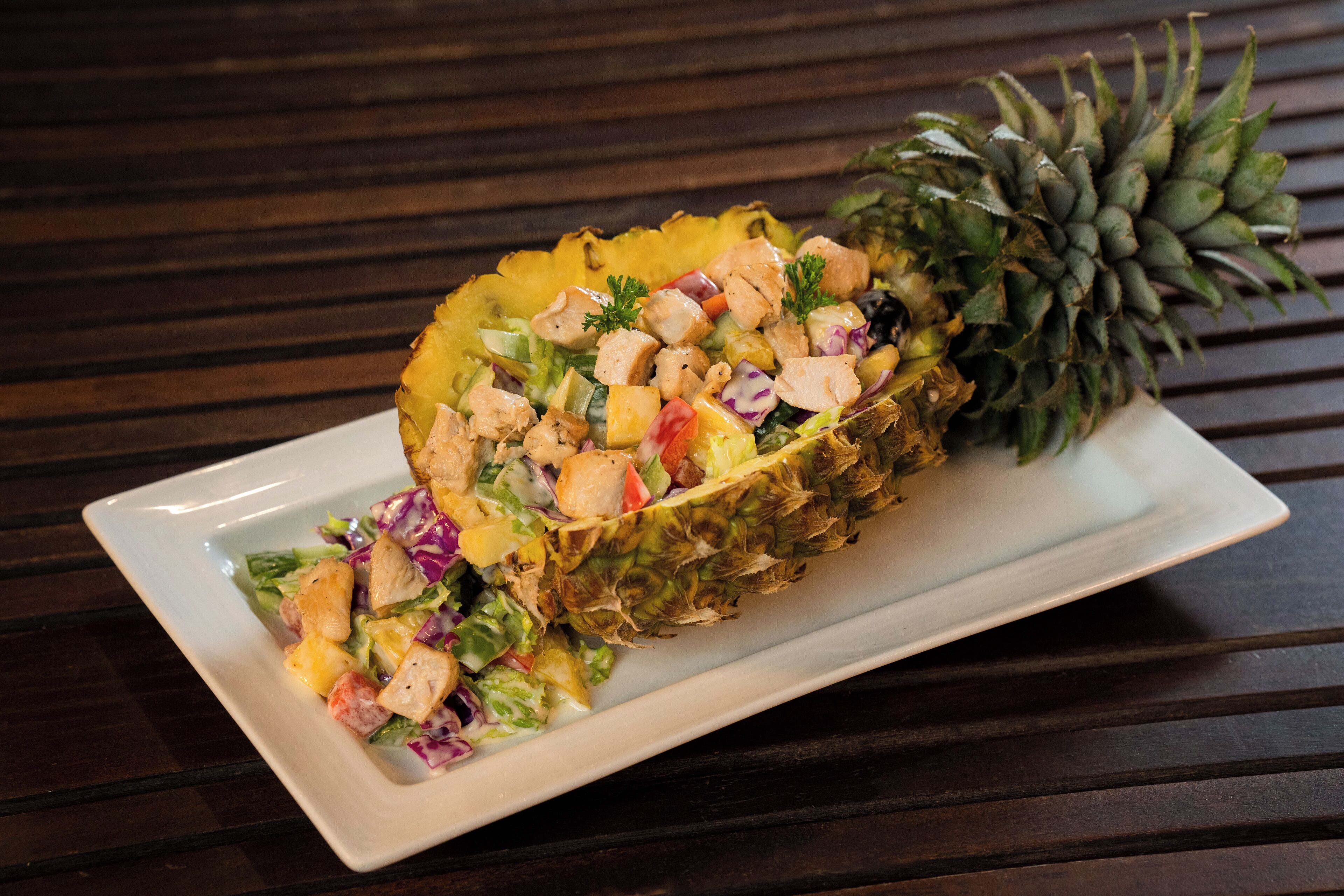 A pineapple bowl salad on a white plate.