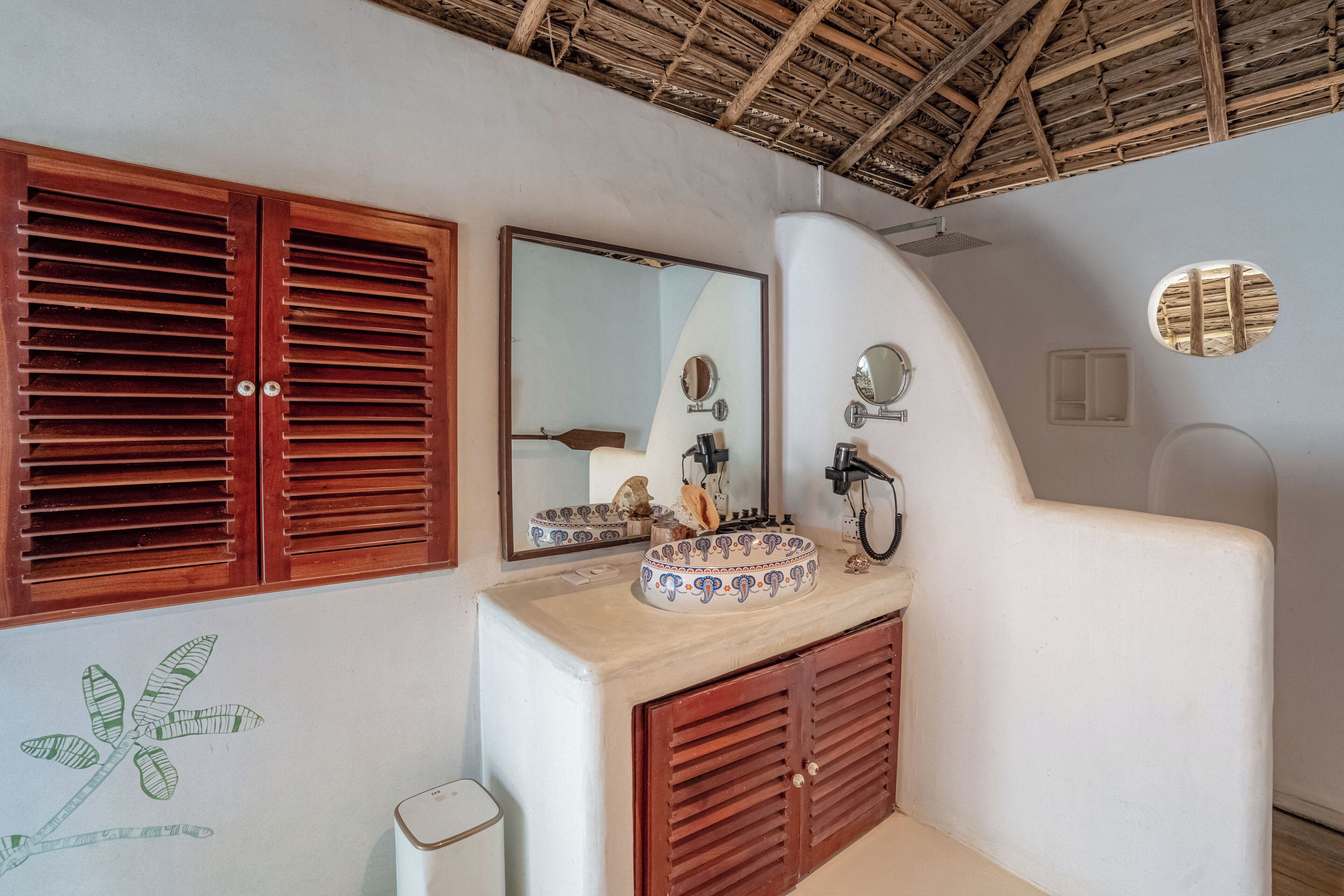 A bathroom with a wooden vanity, a sink with a decorative bowl, and a mirror.