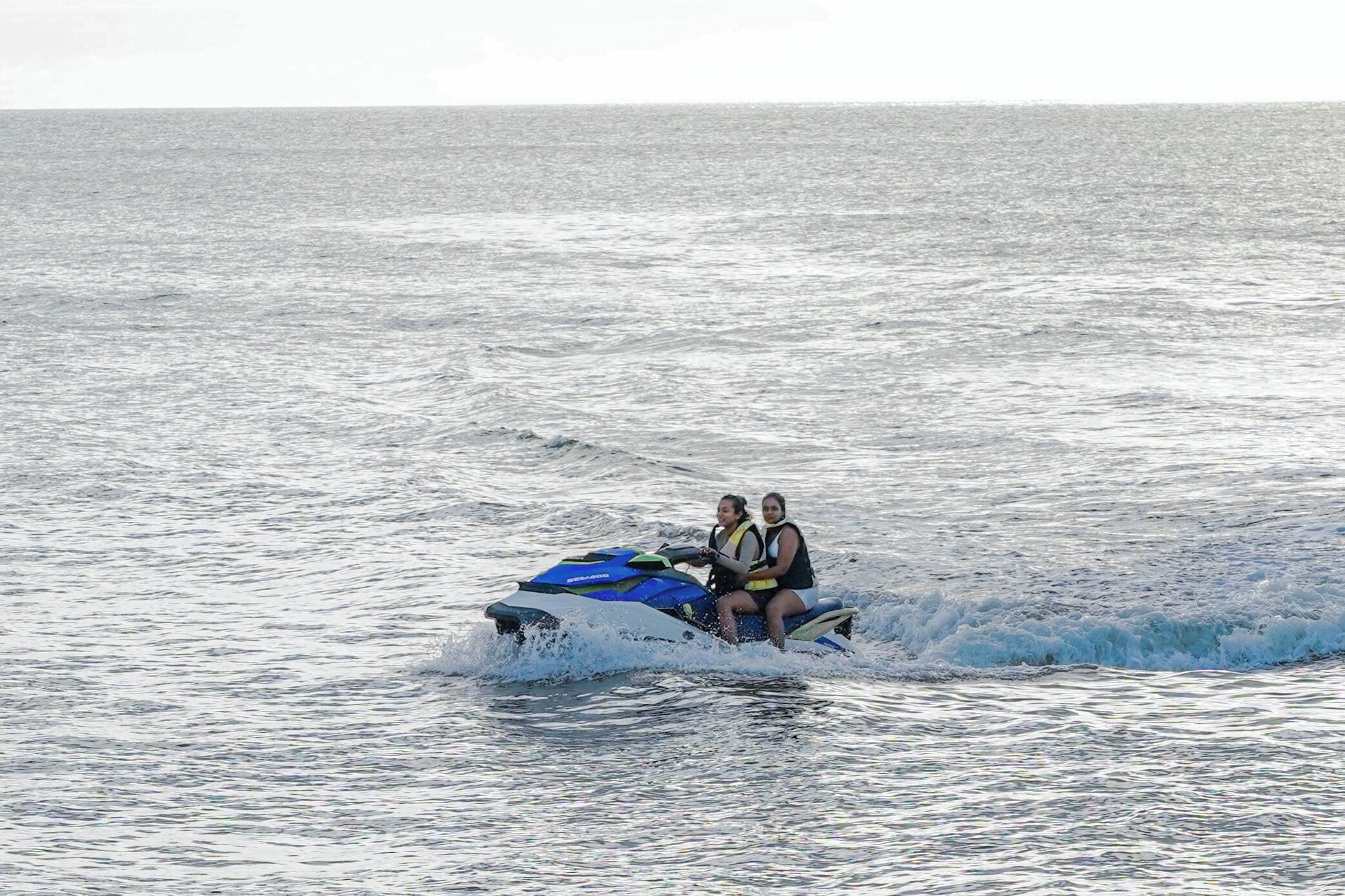 Two people on a jet ski in the ocean.