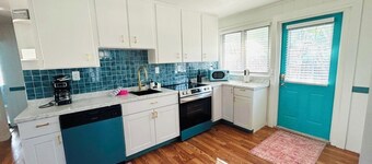 Coastal-chic cottage, two blocks from the  Beach! Freshly renovated 2-bed, 2-bath sleeps up to 8 and blends relaxed island style with modern comforts. Enjoy a full kitchen for easy at‑home meals, smart TVs in every room, and an amazing coastal patio