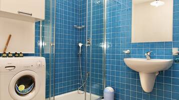 Een douche, een bubbelbad, een bidet, handdoeken