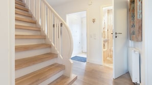 A staircase leading to a bathroom with a white door and a radiator. - Spacious vacation home Lüttje Butt with garden and terrace near the beach on Sylt (List auf Sylt)