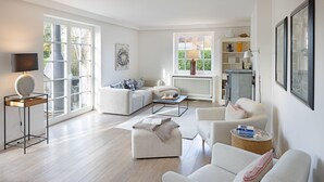 A spacious living room with a sofa set, a coffee table, and a reading area with a lamp. - Spacious vacation home Lüttje Butt with garden and terrace near the beach on Sylt (List auf Sylt)