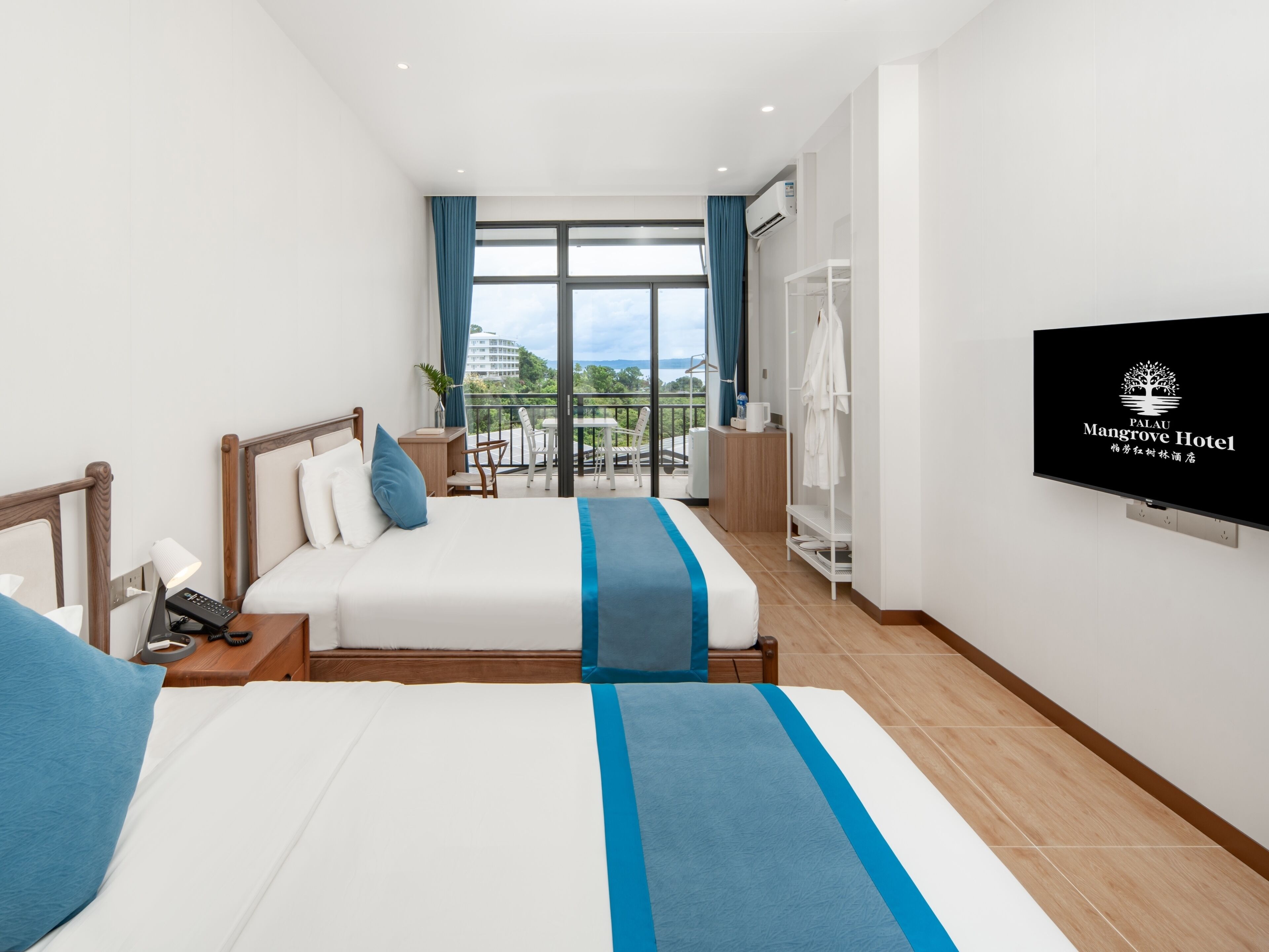 Une chambre d’hôtel avec un lit, une table de chevet, une télévision et un balcon avec vue.