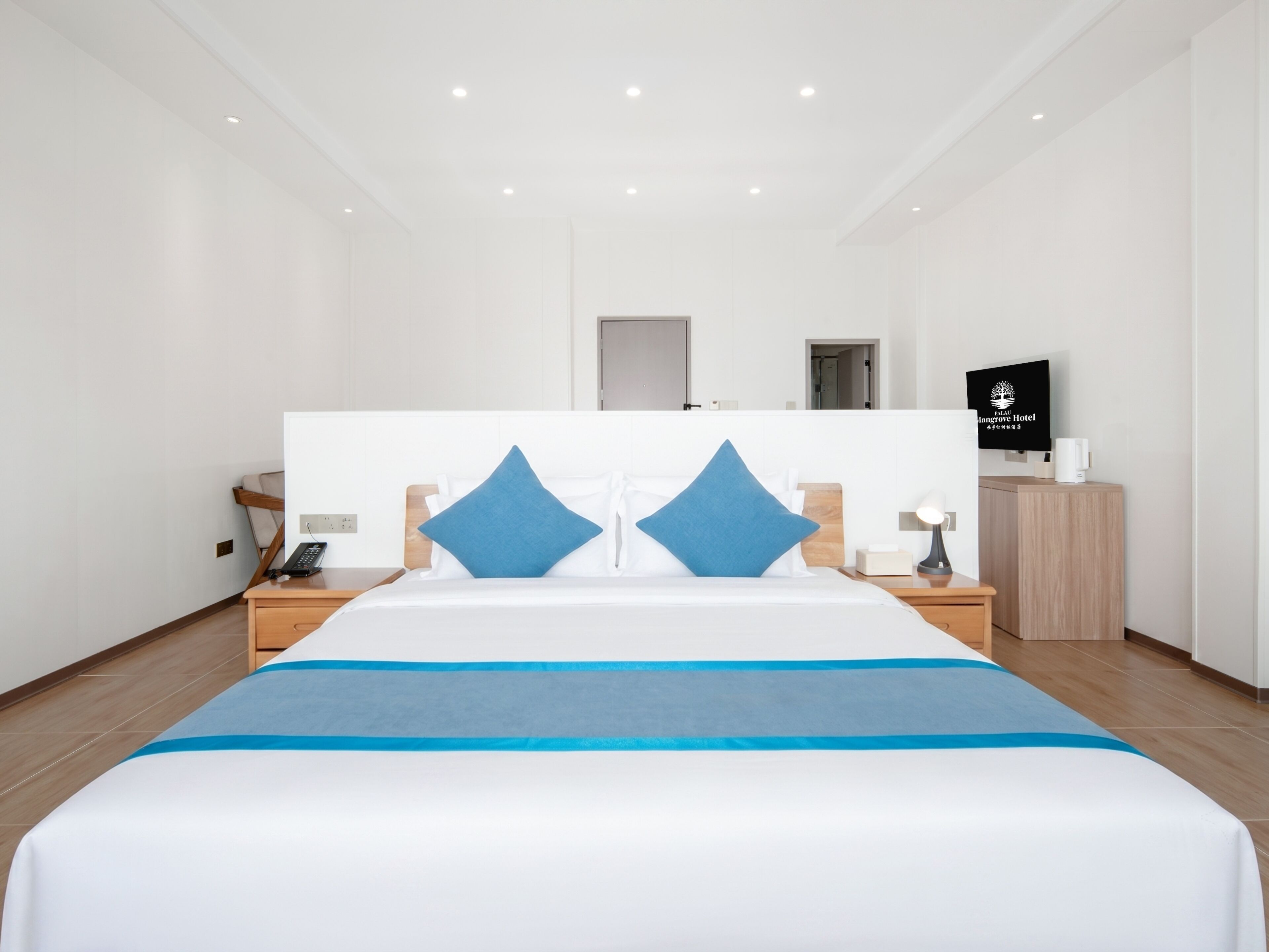 Una habitación de hotel moderna con una cama grande, dos mesitas de noche, un televisor y un escritorio de madera.
