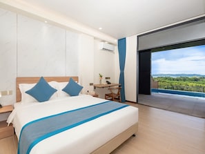 A modern hotel room with a large bed, a desk, and a view of a green landscape. - Palau Mangrove Hotel (Meyungs)