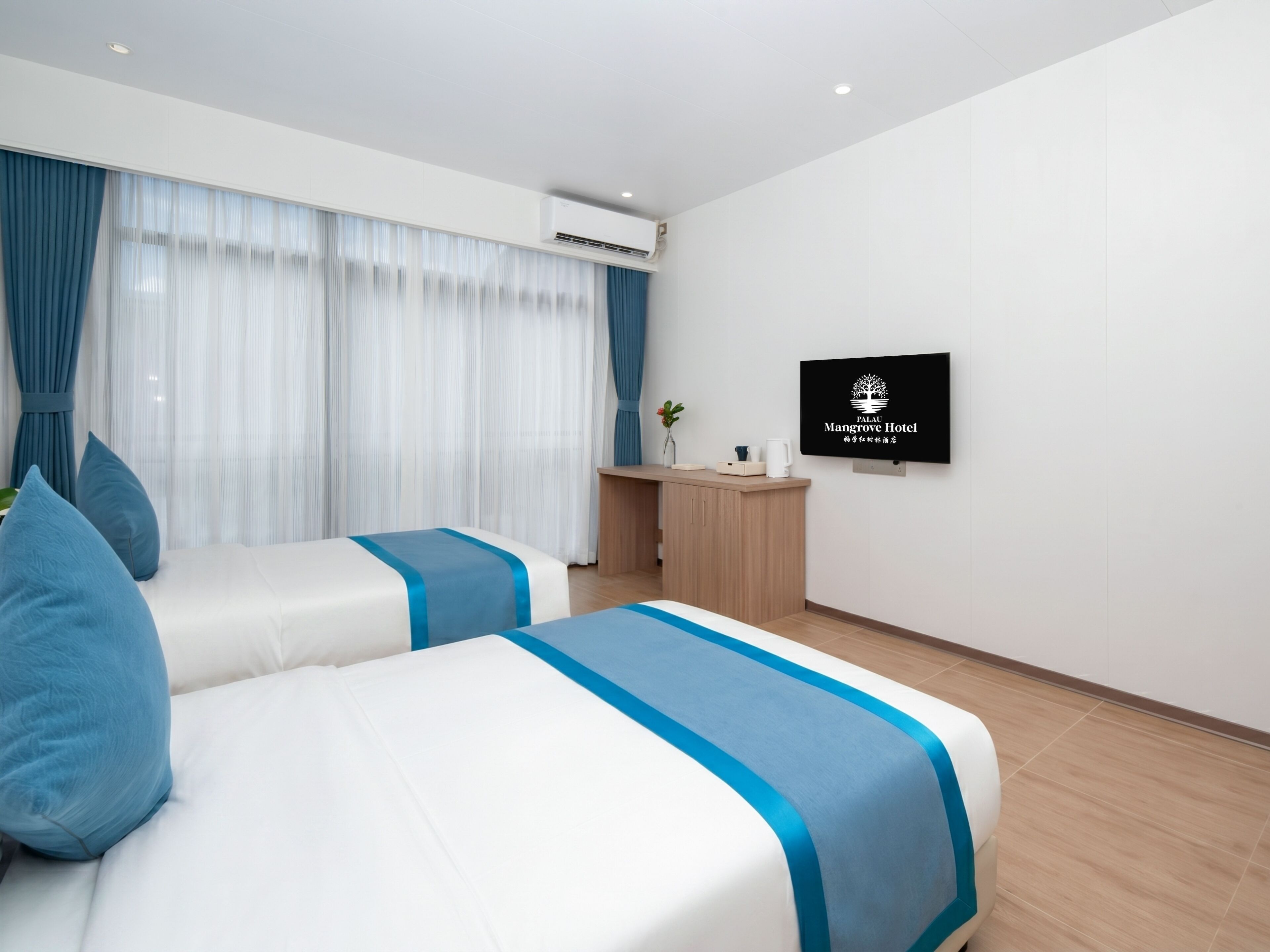 Een hotelkamer met twee bedden, een bureau, een televisie en een raam met gordijnen.