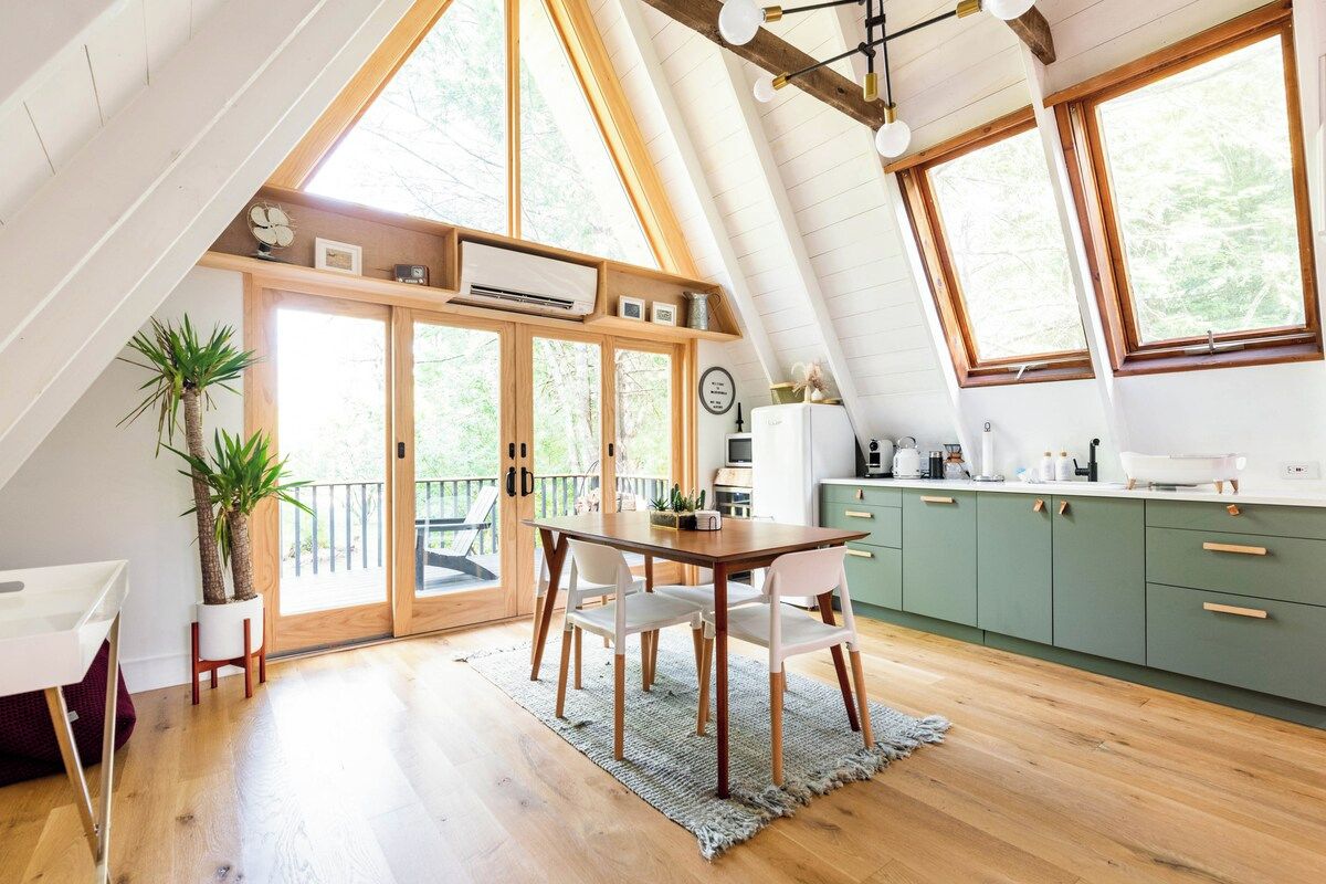 A modern kitchen with wooden cabinets, a dining table, and chairs.