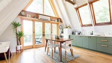 A modern kitchen with wooden cabinets, a dining table, and chairs.