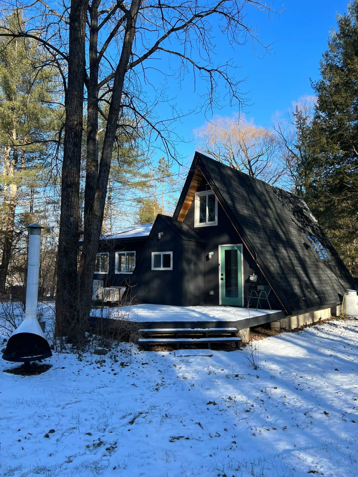 A cabin with a sloped roof, a chimney, and a front porch.