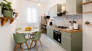 Una cocina compacta con una mesa de comedor, sillas, estufa y microondas.
