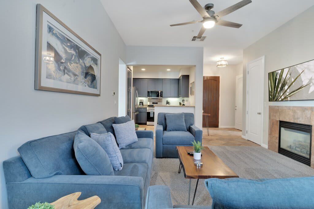 A modern living room with a sofa set, a coffee table, and a fireplace.