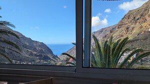 Taula amb vista a un paisatge de muntanyes i al mar.