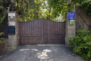 A gated entrance with a stone wall, a metal gate, and a sign indicating a tourist use area. - Holiday Home 'Viria' with Mountain Views, Wi-Fi and Air Conditioning (Navaluenga)