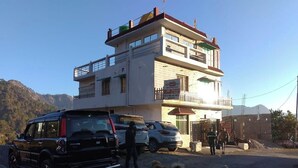 Een gebouw met twee verdiepingen, met een bord waarop staat