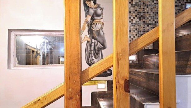 Een trap met houten leuningen en een betegelde muur.
