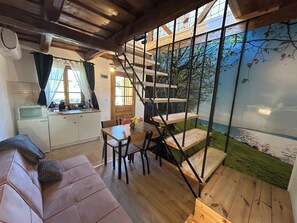 Ein gemütliches Interieur mit einer Holztreppe, einem Essbereich und einer Küche.