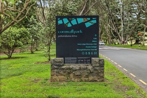 En skylt för Cornwall Park med information om de olika faciliteterna, inklusive ett kafé, en bistro och ett informationscenter.