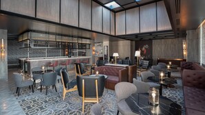 A modern lounge area with seating arrangements, a bar, and a fireplace. - Radisson RED Indore (Indore)