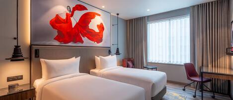 Habitación de hotel con dos camas, un escritorio, una silla y un cuadro abstracto grande en la pared.