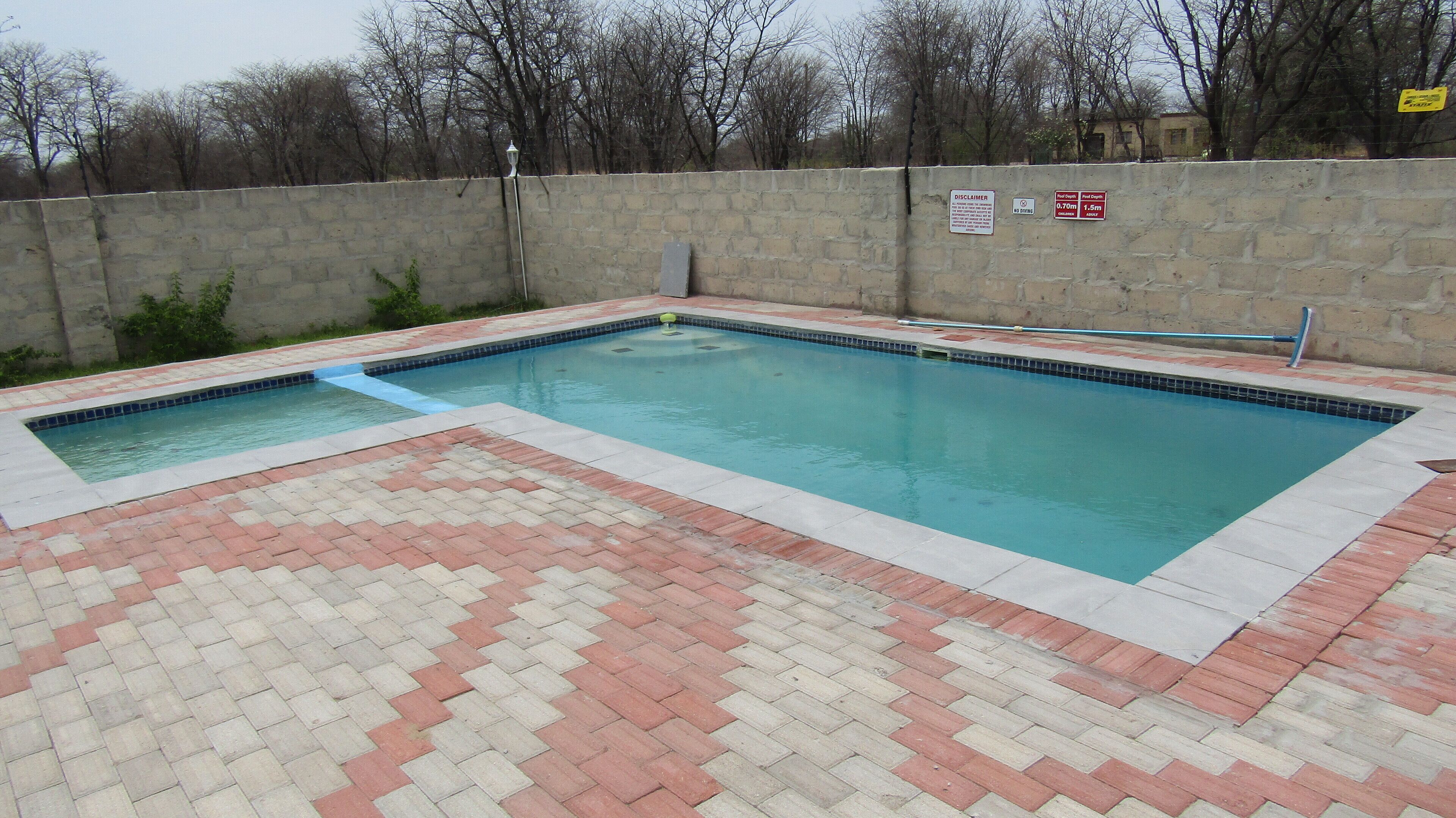 A rectangular swimming pool with a tiled deck.