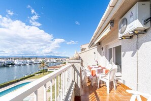 Een balkon met uitzicht op een jachthaven en een zwembad.