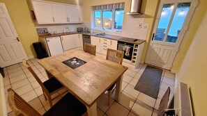 A compact kitchen with a dining table, chairs, and a built-in oven. - Greenway Getaway. Lovely central 3-bedroom townhome in peaceful Westport (Westport)