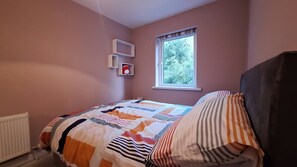 A bedroom with a bed, a window, and a radiator. - Greenway Getaway. Lovely central 3-bedroom townhome in peaceful Westport (Westport)