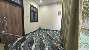 A room with a marble floor, a wooden door, a window, and a metal railing. - Hotel Awadh Pearl (Lucknow)
